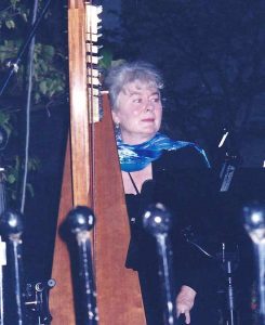 Mary Muckle standing with her harp