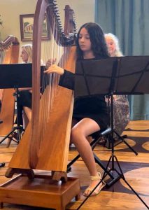 Student playing a harp